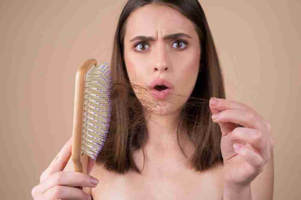 Concerned woman with fallen hair in brush 2 Concerned woman with fallen hair in brush.jpg